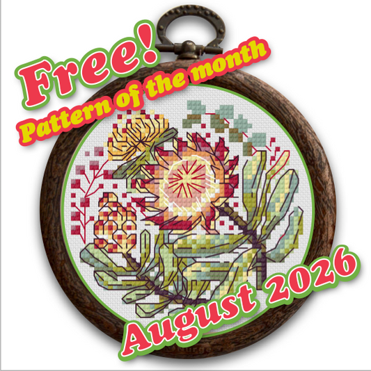 A circular framed cross-stitch pattern featuring a floral design with a prominent red and yellow protea, green leaves, and small yellow flowers. The piece is shown with promotional text reading 'Free! Pattern of the month' and 'August 2026' overlaid on the image.